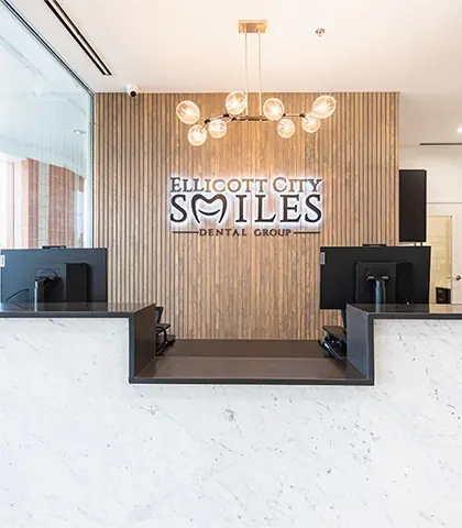 The reception desk in white marble, with the practice's name on the wall behind.